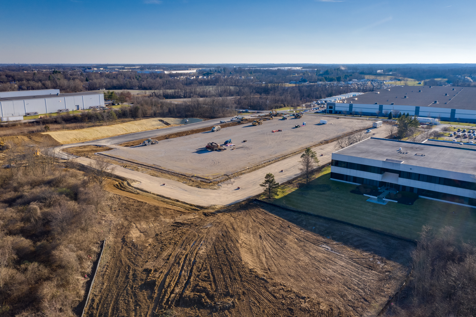 construction site with large empty building slab surrounded by office park.