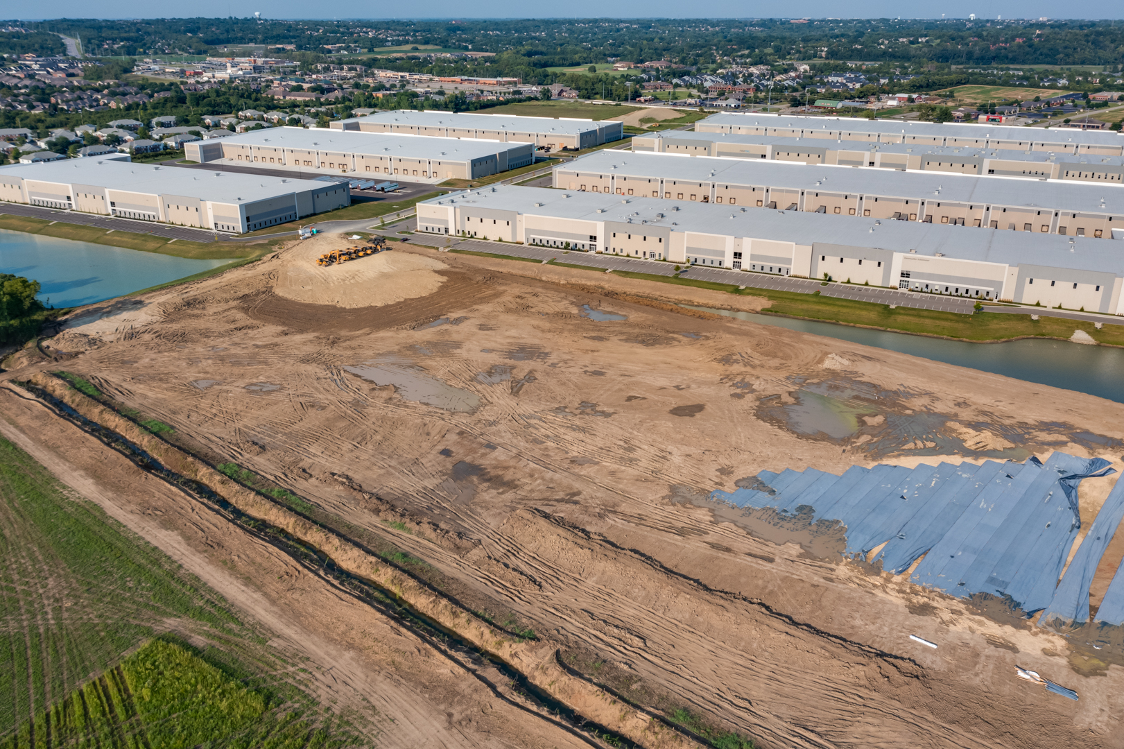 construction site with large empty building slab surrounded by office park.